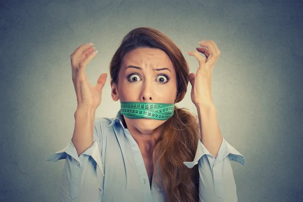 Разочарование женщина с зеленой измерительной ленты вокруг ее рта — стоковое фото