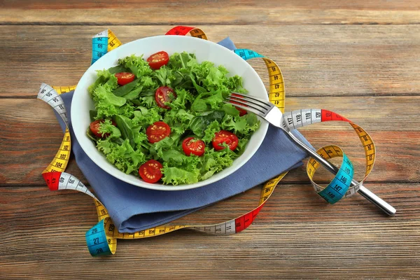 Свежий салат и измерительная лента — стоковое фото